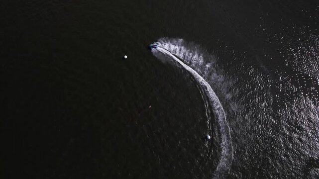 Single Jet Ski Making Sharp Circular Turn on Dark Water Top View