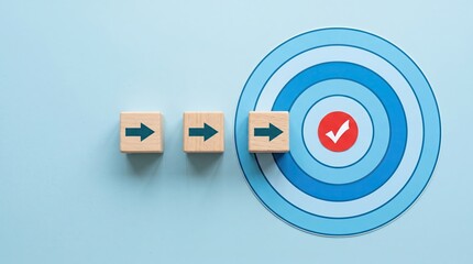 Obraz premium Wooden arrow blocks pointing toward target with checkmark on blue background