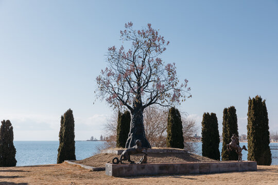 Scenic view of the Ruh Ordo cultural complex with a large tree monument and animal sculptures by the shore of Lake Issyk Kul