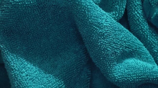 Soft green color cotton towel backdrop, fabric background. Terry cloth bath or beach towels. Macro. Slow motion. 