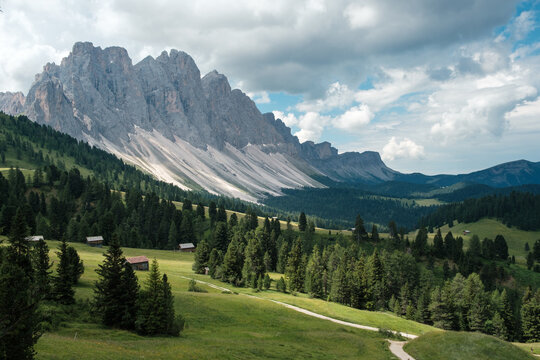 View of the famous peaks of the Geisler Group in the Italian Dolomites, with dark clouds in the background.