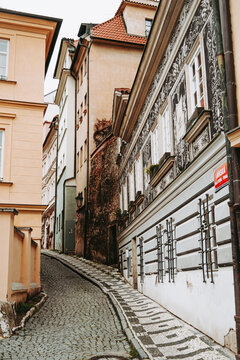 Narrow cobblestone street and traditional sgraffito house in Mala Strana, Prague