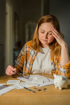 Cost of living crisis concept with worried woman counting coins at home