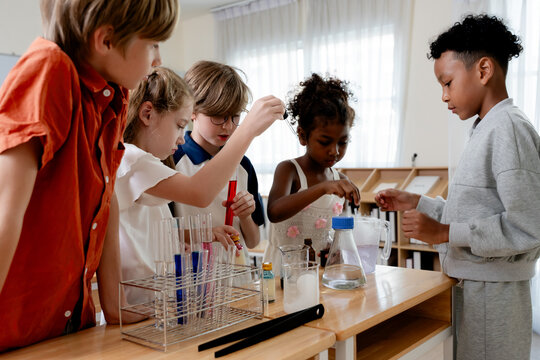 Education concept. Diverse elementary students conducting science experiment in classroom laboratory. test tubes, colorful liquid, promoting STEM education, teamwork, curiosity, learning. education