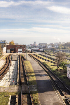 Berlin, Germany - 23 November 2022: View of railway tracks leading to a train depot with passenger trains parked on sidings under a soft morning sky.
