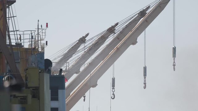 Heavy crane lifting materials at construction site in downtown area during daylight hours