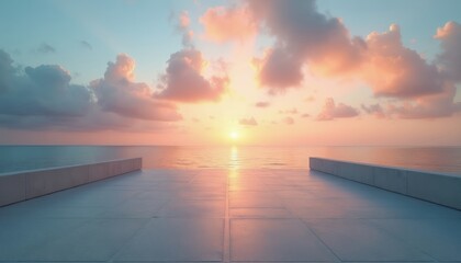 Obraz premium Empty concrete plaza at sunrise over calm ocean. Soft pastel clouds drift across sky reflecting golden light on sea. Serene horizon view offers peaceful tranquil moment.