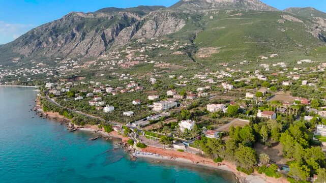 Aerial Drone View of Mikri Mantineia Coastal Village Near Kalamata With Rocky Mountain Slopes, Seaside Homes, Olive Groves and Blue Mediterranean Sea in Greece