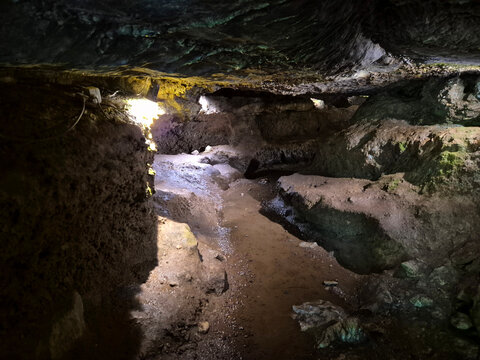 Narrow Cave Passage with Wet Rocky Floor