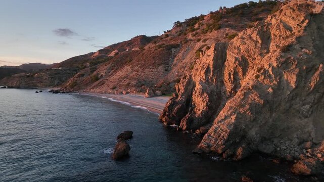 Cinematic Drone Approach Over Mediterranean Sea Revealing Sunset Cliffs and Beach Near Nerja, Andalusia, Spain