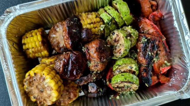 Vegetables such as corn, bell peppers, zucchini, and mushrooms grilled or barbecued, along with salt and spices for the dinner table. Grilled vegetables as a food background for your design