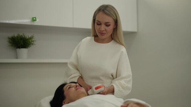 Portrait of professional cosmetologist using ultrasound machine for smas lifting procedure on woman face and neck, providing a non surgical facelift for skin rejuvenation and tightening.