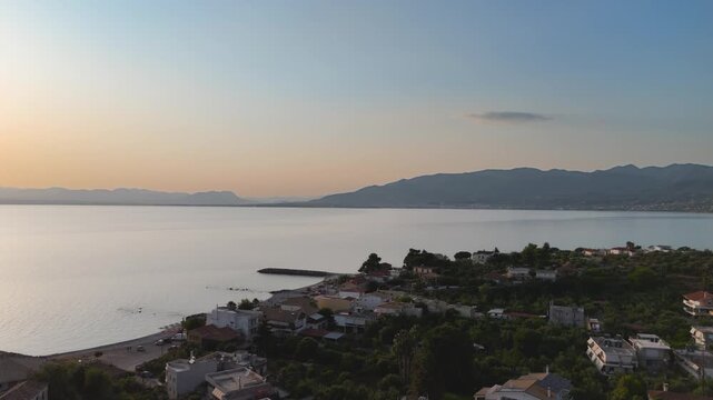 Peaceful Sunset Over Coastal Village and Calm Sea in Mikri Mantineia near Kalamata, Greece, Aerial Drone View of Mountains and Mediterranean Bay