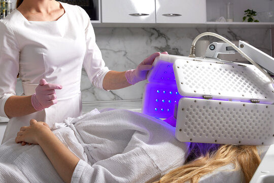 Young woman having photodynamic therapy in beauty salon