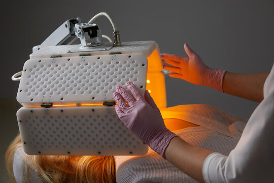 Young woman having photodynamic therapy in beauty salon