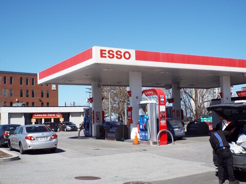 Gatineau, Quebec, Canada &ndash; April 18, 2026: An "Esso gas station" features a red and white canopy over fuel pumps with a Couche-Tard convenience store in the background at 480 Boulevard Saint-Joseph.