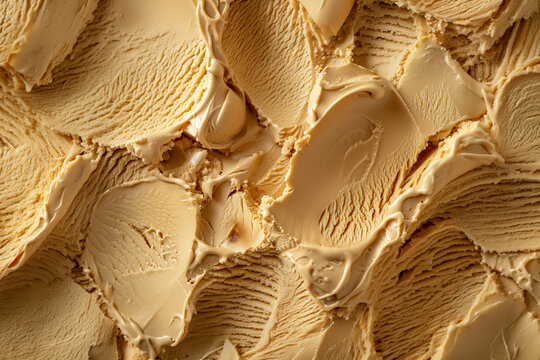Texture de cr&egrave;me glac&eacute;e saveur dulce de leche en relief avec traces de cuill&egrave;re dans une composition gourmande monochrome beige, visuel dessert pour glace, caramel, fond alimentaire et douceur