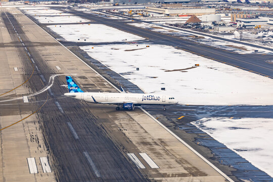 New York, USA - 22.01.2026: JetBlue Airbus A321 airplane taxiing on snow covered runway at JFK International Airport in New York City during winter