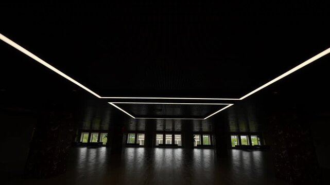 A dark room with columns and windows at the end. Hall with columns in the dark. Dolly camera