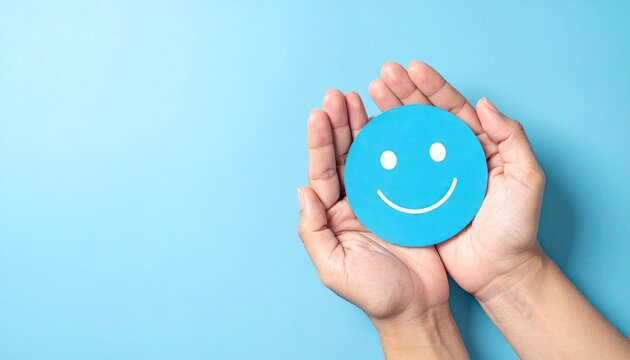 Hands holding blue smiley face on matching background conceptual image