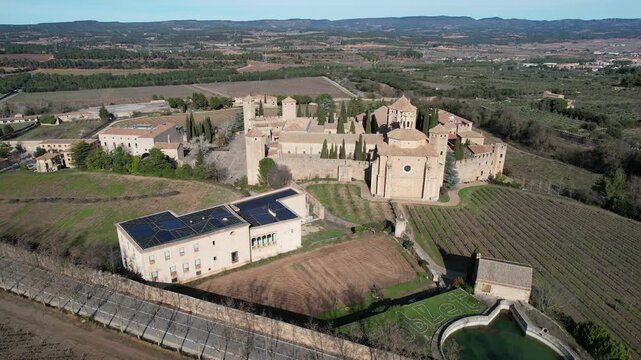 Tilt down aerial shot of Santa Maria de Poblet Monastery on sunny winter day. Tarragona Province, Spain.
