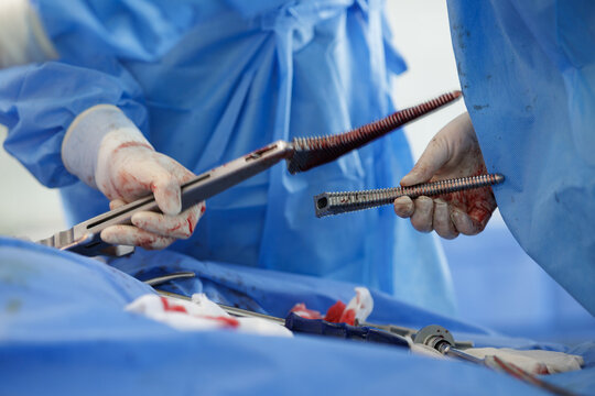 Surgeon Holding Surgical Tools During Hip Replacement Procedure