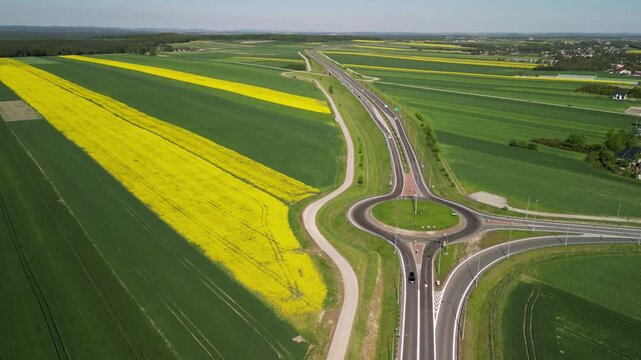 Wojew&oacute;dztwo Świętokrzyskie - Polska - pola rzepaku w rozkwicie, piękny ż&oacute;łty kolor i krajobraz wiejski nagrany z użyciem drona. Rzepak, pola, drogi, niebo, krajobraz wiejski