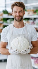 Fototapeta premium Man holding large dough ball in supermarket produce section
