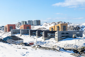Modern arctic residential architecture with apartment buildings and contemporary housing blocks on a snowy rocky hillside in clear daylight, Nuuk, Sermersooq, Greenland © vadim.nefedov