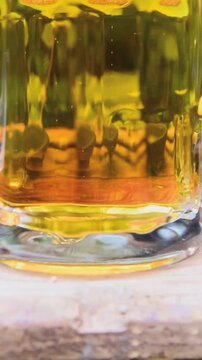 Close-up of bubbles rising in golden sparkling beer mug on a wooden surface