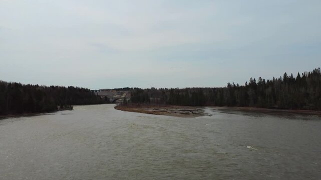 Drone footage captures a dramatic near-miss with Canada geese flying low above the muddy spring floodwaters of the Mitis River in Quebec, Canada.