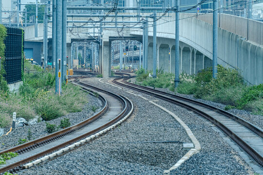Curving railway tracks under overhead catenary lines through Tokyo urban infrastructure