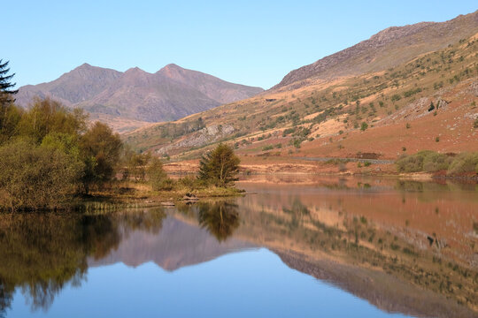 A calm Llynnau Mymbyr lake looking towards the Snowdon Horseshoe, part of the Snowdon Yr Wyddfa massif, in northern Eryri National Park, formally Snowdonia, Wales, UK.