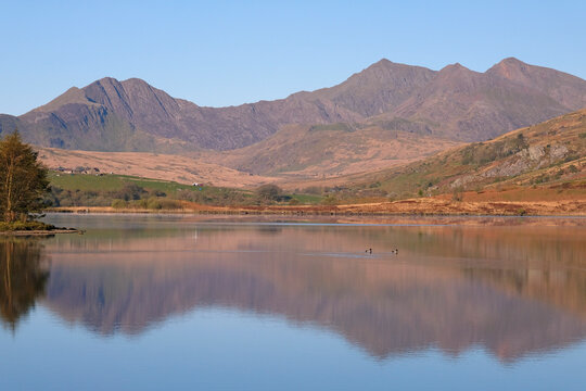 A calm Llynnau Mymbyr lake looking towards the Snowdon Horseshoe, part of the Snowdon Yr Wyddfa massif, in northern Eryri National Park, formally Snowdonia, Wales, UK.