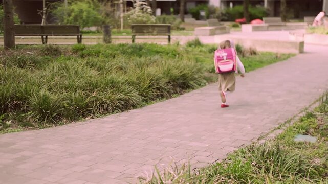 young schoolgirl with backpack walking home from school, calm after classes, daily routine, childhood independence, back to school, First grader returns home enjoying calm day, peaceful Childhood