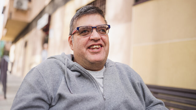 Happy man with glasses and disability smiling outdoors, representing inclusion, diversity, and community