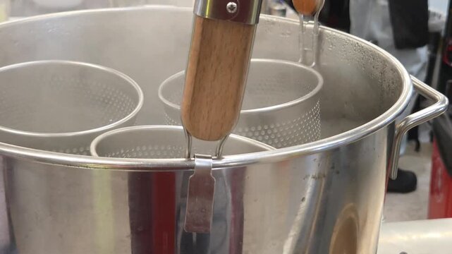 Close-up of Noodle Strainers in Boiling Water Steaming in Professional Kitchen 