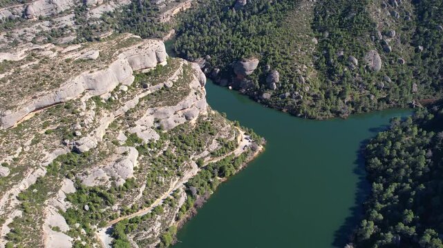 Rising up aerial shot of Margalef reservoir on sunny winter day. Tarragona Province, Spain.
