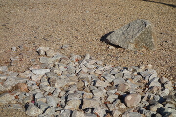 Large weathered granite boulder and rocks set on a bed of fine gravel in a desert-style xeriscaped ground, natural background, backdrop © EuToch