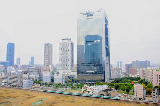 大阪のビルを背景に走る特急列車