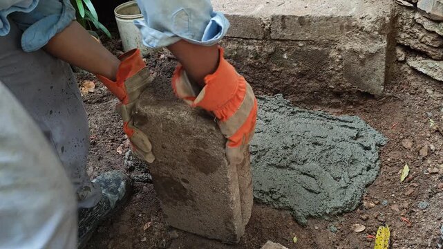 Mason placing two bricks to build a handmade staircase step