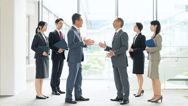 オフィスで会話するビジネスパーソンのグループ