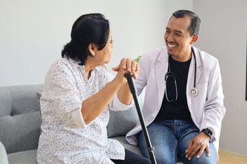 Obraz premium Asian male Doctor with senior woman talking and having fun at home or nursing home