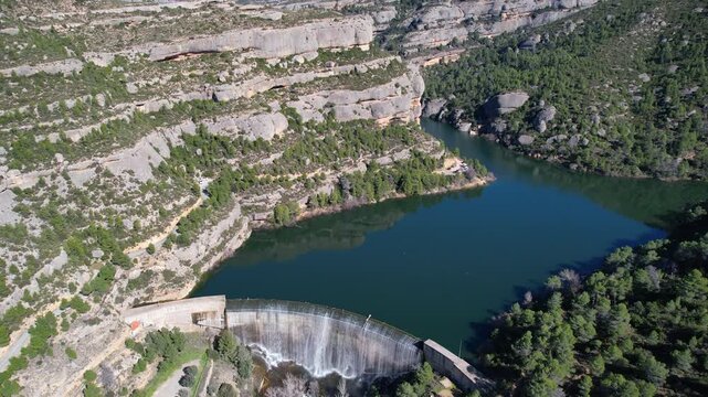Forward reveal aerial footage of Margalef reservoir on sunny February day. Tarragona Province, Spain.