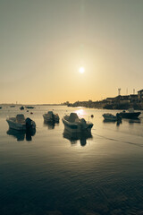 Fototapeta premium Boats Anchored at Cais de Sao Jacinto Pier in Aveiro Portugal at Sunset