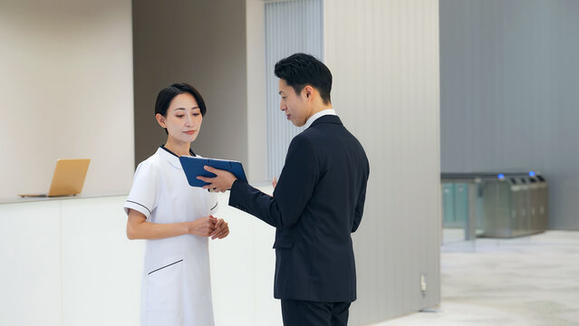 営業に説明を受ける女性医療スタッフ