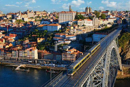 Sunrise morning view of Porto and Ribeira with a tram on Dom Luis I Bridge and warm sunrise light over the Douro River in Portugal