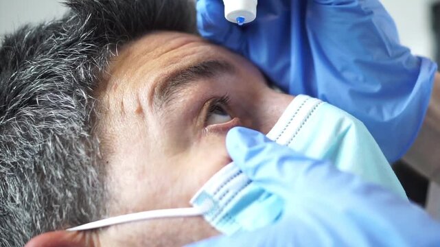 A close-up showing the wrong way to administer ophthalmic solution, where the dropper tip or the hand's positioning may compromise sterility or safety during patient care.