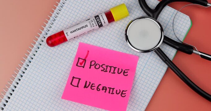 Medical vial of Hantavirus on a paper notebook with pink notes and a stethoscope. Red gradient background symbolizes a health emergency and research.