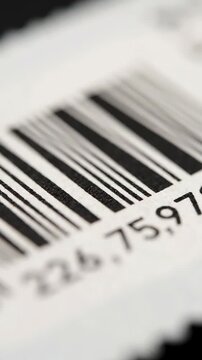 Macro close-up of a barcode on a white surface displaying numbers and black lines representing product identification and retail concepts with technology and data